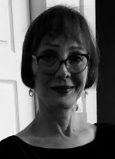 A person in glasses looking at the camera Description generated with very high confidence